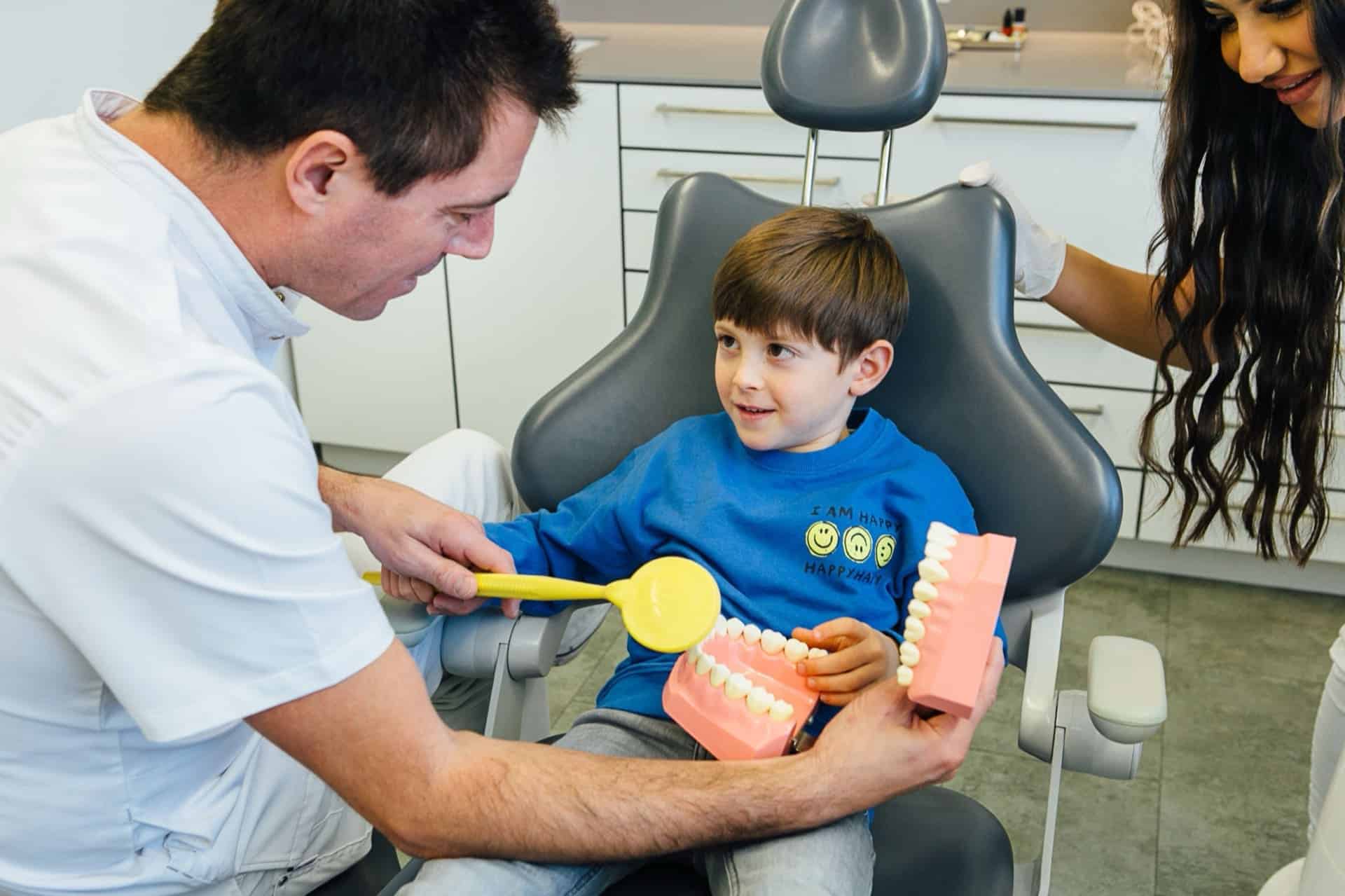 Dr. Bernd Kinast erklärt einem Kind ruhig und spielerisch den Ablauf der Behandlung