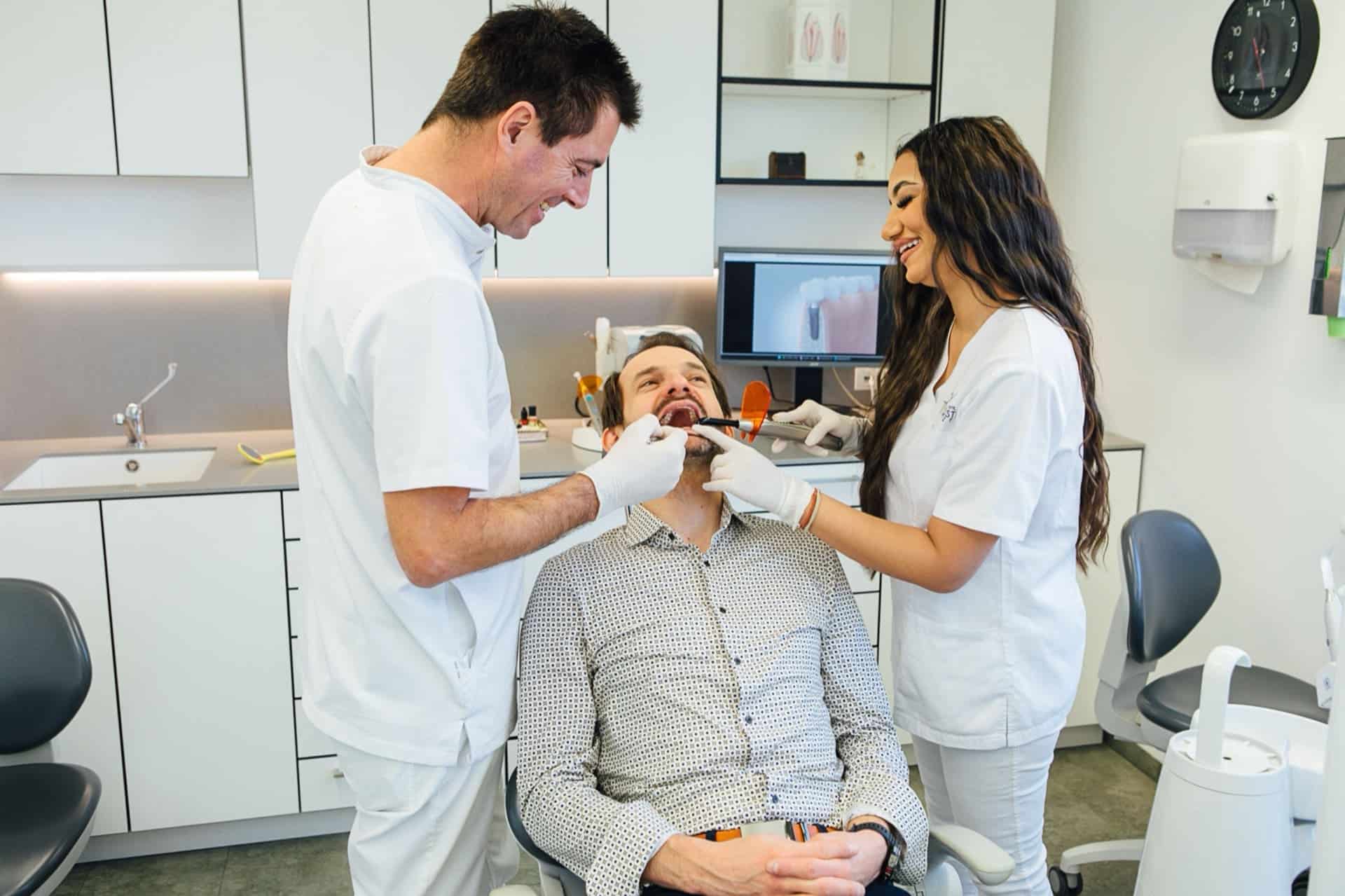 Dr. Bernd Kinast erklärt einem Patienten einen Behandlungsablauf in ruhiger Praxisatmosphäre